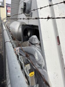 Kitchen Guard of El Paso technician cleaning a rooftop kitchen exhaust fan