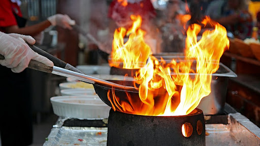 A close up image of high heat cooking in a commercial kitchen.