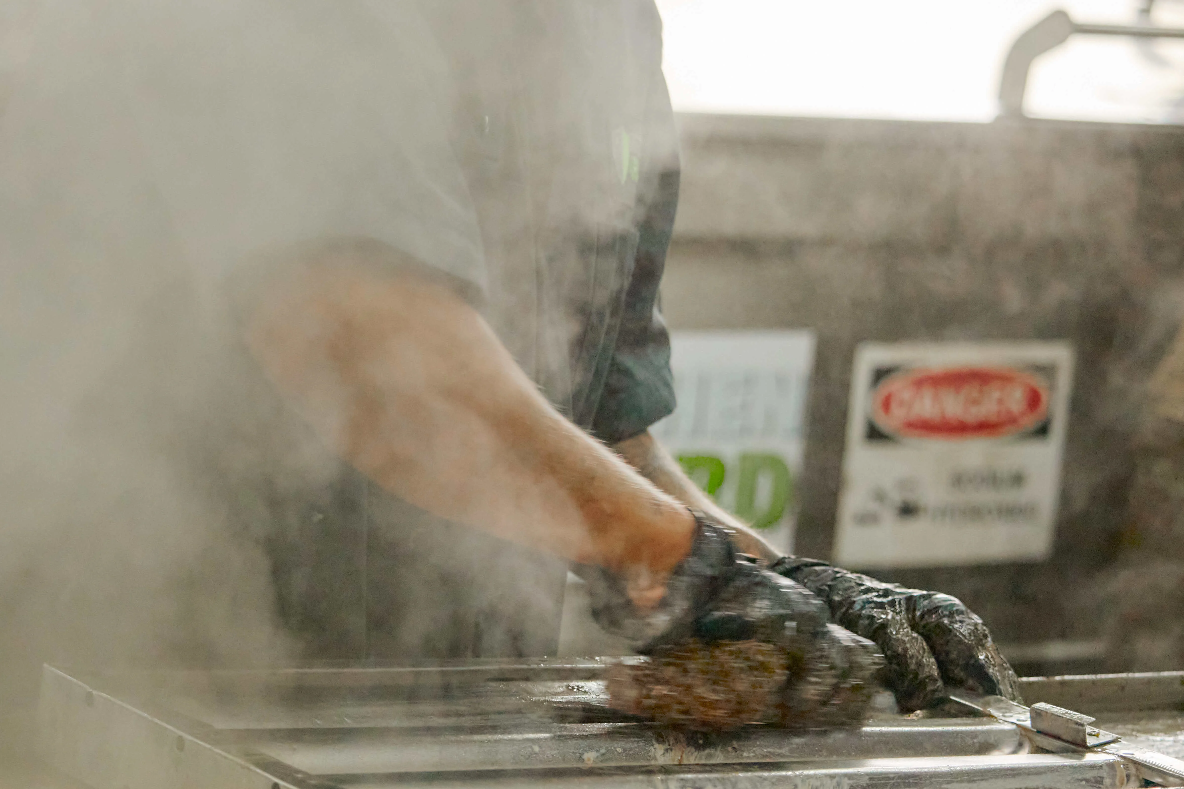 Kitchen Guard technician scrubbing commercial hood baffle filters during a scheduled exhaust cleaning