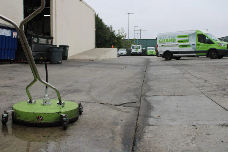 Commercial pressure washing crew cleaning a dumpster pad in Northeast Atlanta