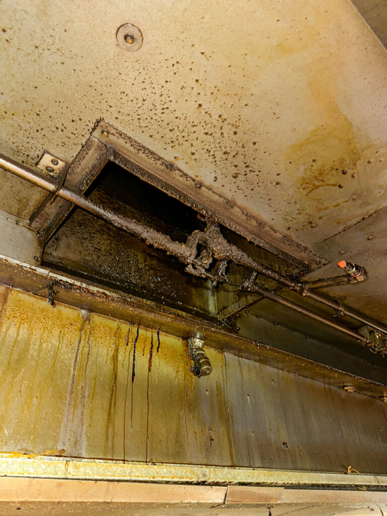 A dirty and greasy kitchen hood in a commercial restaurant