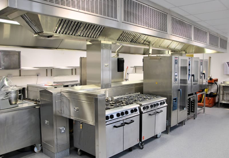 Image of a large commercial kitchen featuring stainless steel appliances